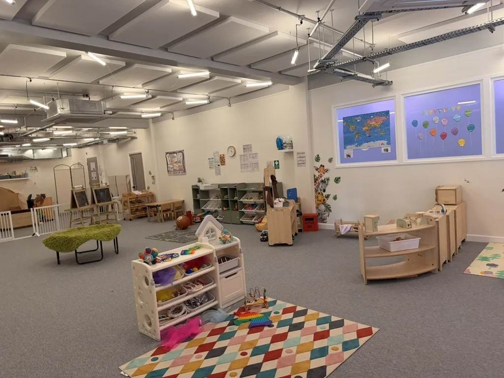 Wide view of the nursery playroom and colourful activity rug